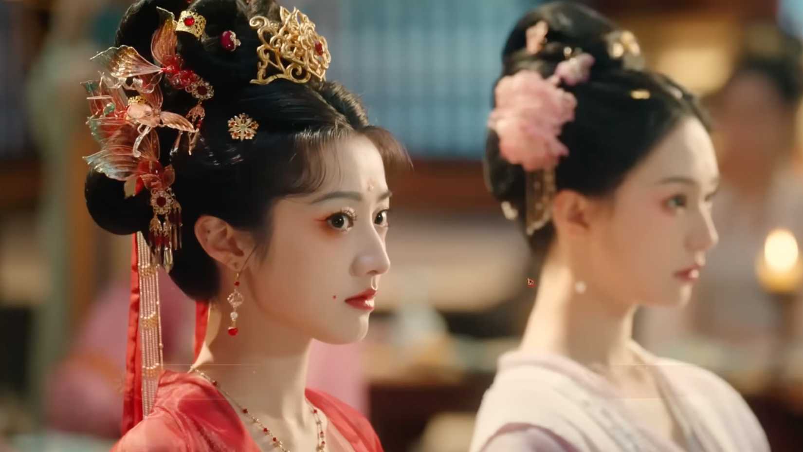 Der Spielercharakter trägt ein aufwendiges rotes Kleid mit passenden Haarteilen.